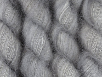 A close up of warm semi-solid grey with hints of silver and graphite coloured skeins of superfine kid mohair and silk 2ply lace yarn (Fog Bound on Kid Glove Lace)